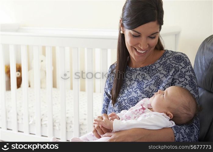 Happy Mother Sitting In Nursery With Baby