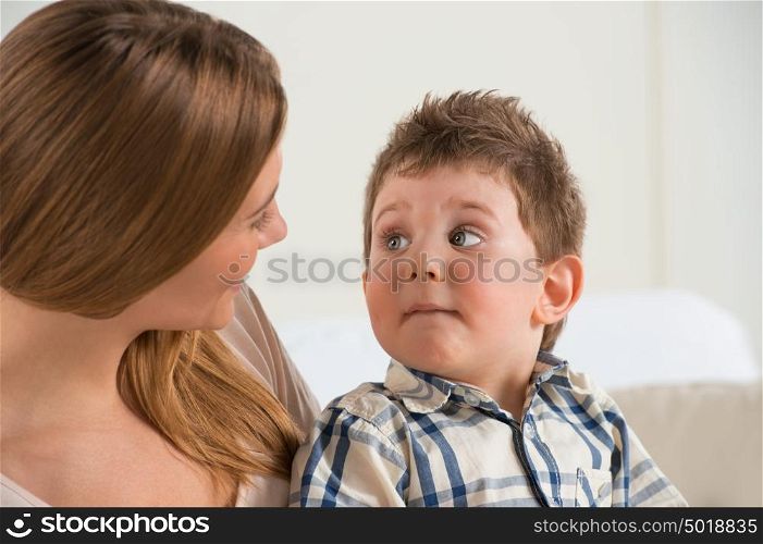 Happy mother talking to her son at home