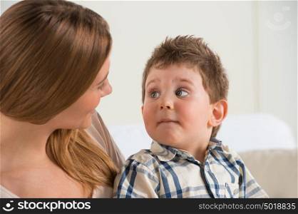 Happy mother talking to her son at home
