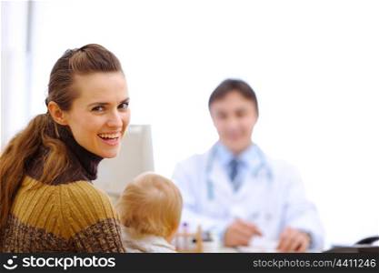 Happy mother with baby at pediatric doctor cabinet&#xA;