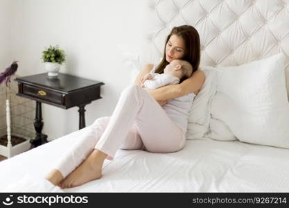 Happy mother with baby on bed