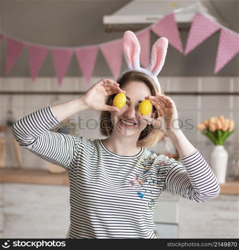 happy mother with bunny ears holding easter eggs