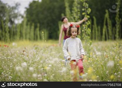 Happy mother with her little daughter in poppy field. Mother with her little daughter in poppy field
