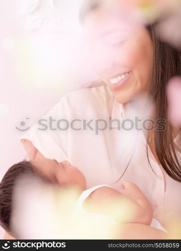 Happy mother with little newborn baby at home, embracing cute daughter, soft focus, enjoying parenthood, child care and healthy lifestyle concept