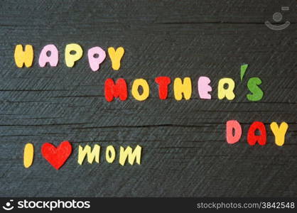 Happy mothers day with i love mom message, idea from colorful letter on wooden background, woman hand cutting character to make gift for mother on happy day, show feeling with mother, love family