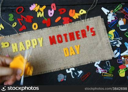 Happy mothers day with i love mom message, idea from colorful letter on wooden background, woman hand cutting character to make gift for mother on happy day, show feeling with mother, love family
