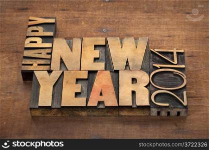 Happy New Year 2014 greetings or wishes - text in vintage letterpress wood type blocks on a grunge wooden background