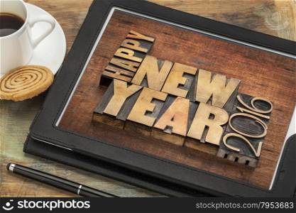 Happy New Year 2016 greetings - text in vintage letterpress wood type blocks on a digital tablet with a cup of coffee