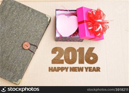 Happy New Year 2016 with book and gift on vintage brown background