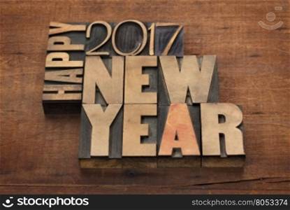Happy New Year 2017 greeting card - text in vintage letterpress wood type blocks on a grunge wooden background