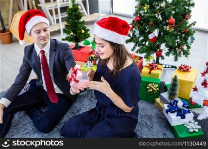 Happy new year 2020 concept,Happy couple holding exchanging gifts and Give a present in Christmas and New Year&rsquo;s Eve party Christmas tree background After finishing business work