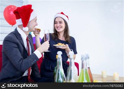 Happy new year 2022 concept,Happy couple Hold a glass of champagne and eat the cookies in Christmas and New Year&rsquo;s Eve party After finishing business work