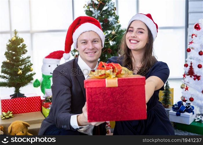 Happy new year 2022, concept,Happy couple holding exchanging gifts and Give a present in Christmas and New Year&rsquo;s Eve party Christmas tree background After finishing business work