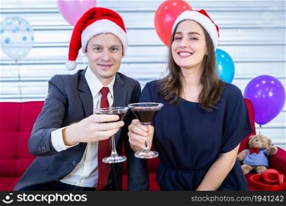 Happy new year 2022 concept,Happy couple holding glasses of Clinking Champagne in Christmas and New Year&rsquo;s Eve party After finishing business work