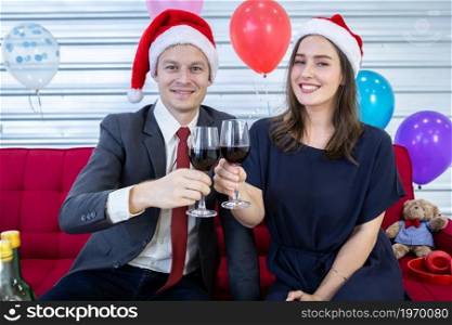 Happy new year 2022 concept,Happy couple holding glasses of Clinking Champagne in Christmas and New Year&rsquo;s Eve party After finishing business work