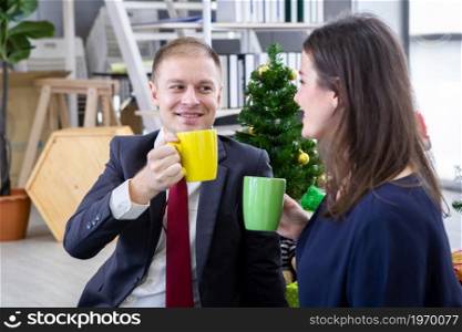 Happy new year 2022 concept, Happy couple holding the having cup of coffee,milk or chocolate in Christmas and New Year&rsquo;s Eve party Christmas tree background After finishing business work