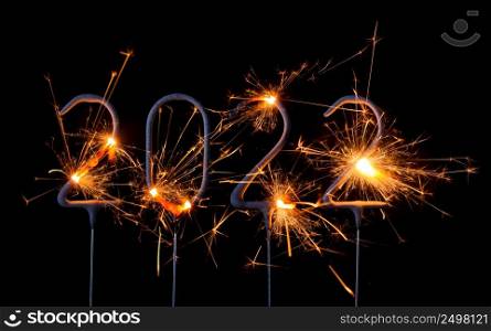 Happy New Year 2022. Digits of year 2022 made by burning sparklers isolated on black background.