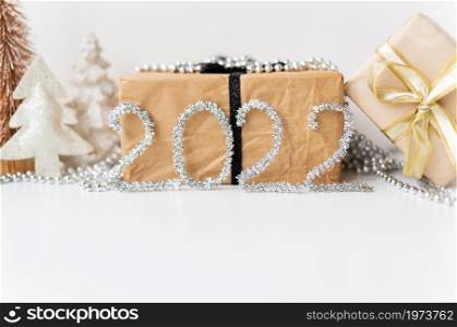 Happy New Year 2022. Festive gold decor - a tree, a gift, a star, tinsel. Empty space for an inscription. Happy New Year 2022. Festive gold decor - a tree, a gift, a star, tinsel. Empty space for an inscription.