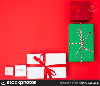 Happy New Year and Christmas 2020 day, top view Xmas multi color gift boxes on red background with copy space for your text