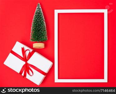 Happy New Year and Christmas 2020 day, top view Xmas white gift boxes & fir tree on red background with copy space for your text