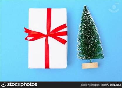 Happy New Year and Christmas 2020 or valentine day, top view craft paper wrapped present gift box craft and fir tree on blue background with copy space for your text