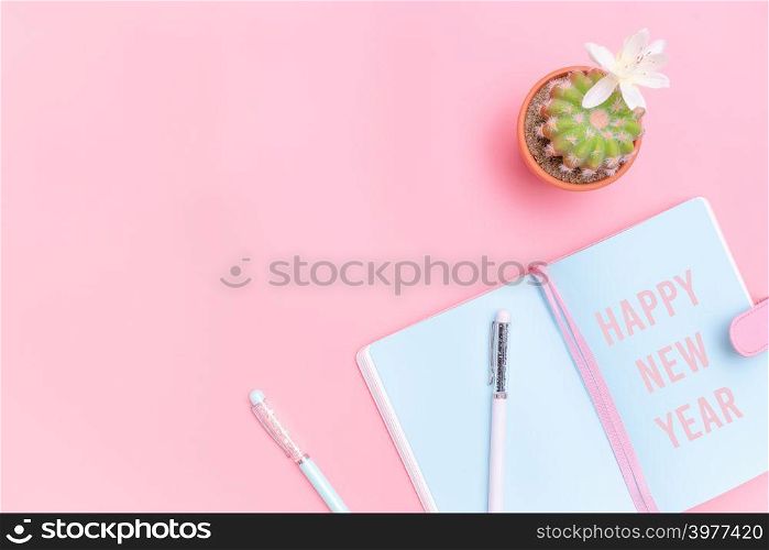 Happy New Year concept, workspace desk styled design office supplies and cactus on pink pastel background minimal style