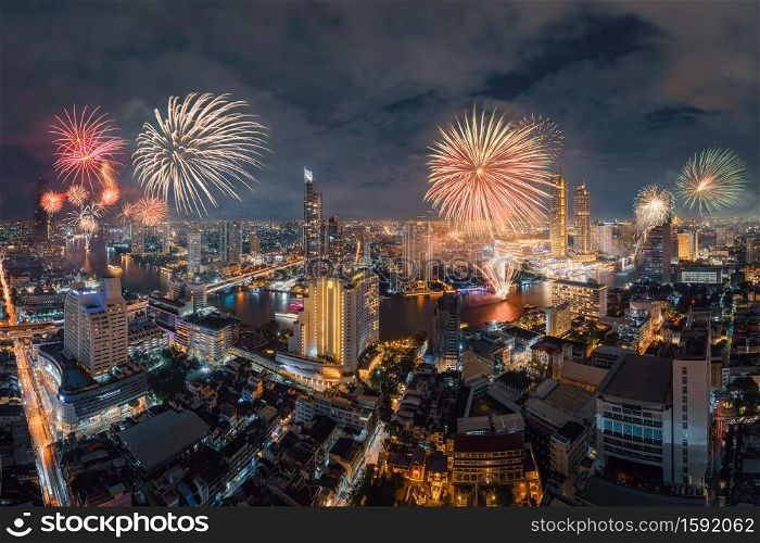 Happy New Year Fireworks Festival Event at Taksin bridge with Chao Phraya River in Bangkok, Thailand. Financial district and skyscraper buildings. Downtown skyline at night.