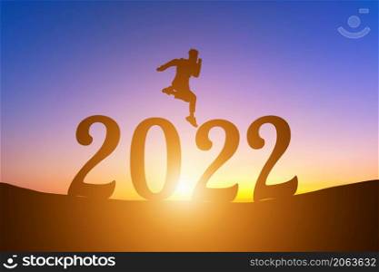 Happy New Year Numbers 2022, Silhouette a man handsome jumping feels happy moving early morning sunrise over the horizon background, Health and Happy new year concept.