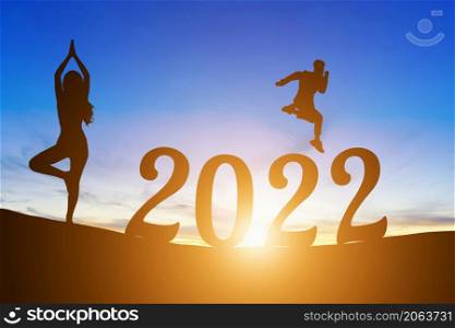 Happy New Year Numbers 2022, Silhouette a man handsome jumping feels happy moving and woman practicing yoga early morning sunrise over the horizon background, Health and Happy new year concept.