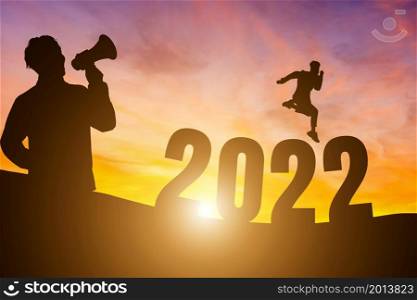 Happy New Year Numbers 2022, Silhouette a man handsome wearing shouting with megaphone and man jumping feels happy moving morning over the horizon background, Health and Happy new year concept.