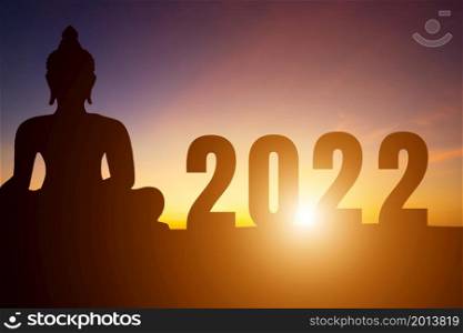 Happy New Year Numbers 2022, Silhouette Buddha statue early morning sunrise over the horizon background,Happy new year concept.