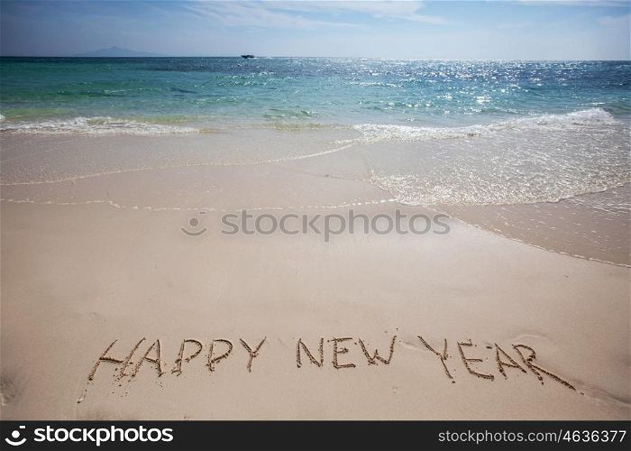 Happy new year on beach. Happy new year handwriting on tropical sea beach