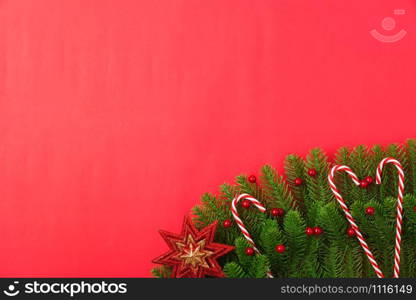 Happy new year or christmas day top view flat lay fir tree branches and ornaments decoration on red background with copy space for your text