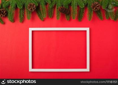 Happy new year or christmas day top view flat lay fir tree branches and decoration photo fram on red background with copy space for your text