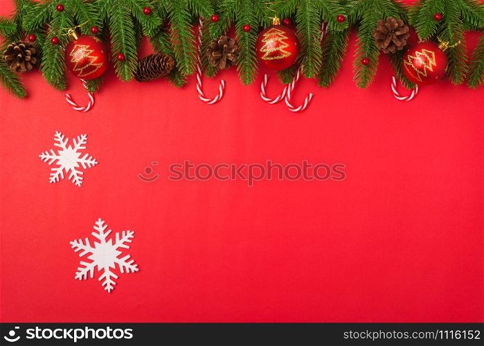 Happy new year or christmas day top view flat lay fir tree branches and decoration on red background with copy space for your text