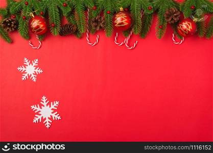 Happy new year or christmas day top view flat lay fir tree branches and decoration on red background with copy space for your text