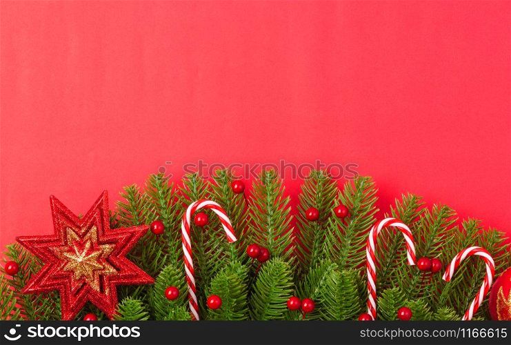 Happy new year or christmas day top view flat lay fir tree branches and ornaments decoration on red background with copy space for your text