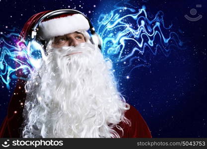 Happy New Year. Santa Claus wearing headphones and enjoying music