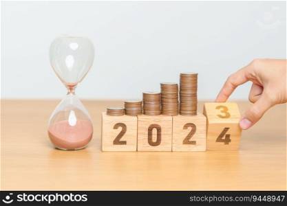 Happy New Year with sandglass and flipping 2023 change to 2024 block. Resolution, Goals, Plan, Action, Money Saving, Retirement fund, Pension, Investment and Financial concept