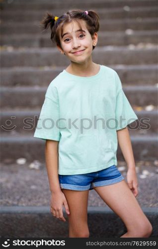 Happy Nine-year-old girl standing on the steps of a city park.. Nine-year-old girl standing on the steps outdoors