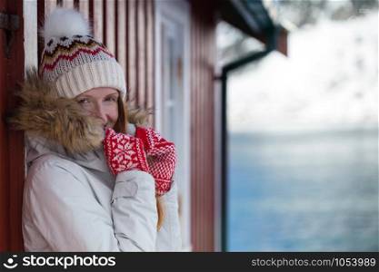 happy norwegian girl pose for the camera in red mittens with a Norwegian pattern. Lofoten islands. Norway