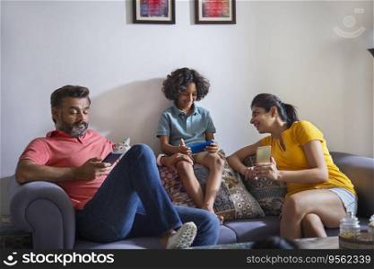Happy nuclear family using smartphone in living room