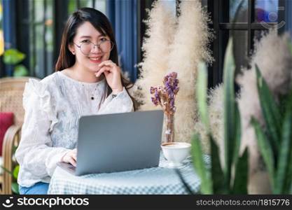 Happy of asian freelance people business female casual working with laptop computer with coffee cup and smartphone in coffee shop like the background,communication concept