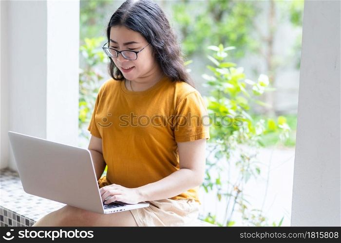 Happy of asian freelance people business female casual working with laptop computer sitting on a bench in coffee shop like the background,communication concept
