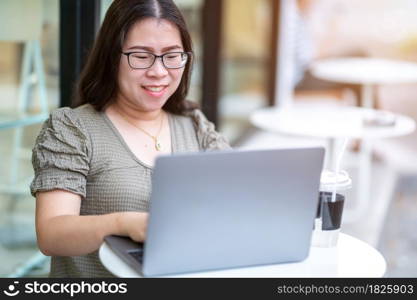 Happy of asian freelance people business female casual working with laptop computer with coffee cup and smartphone in coffee shop like the background,communication concept