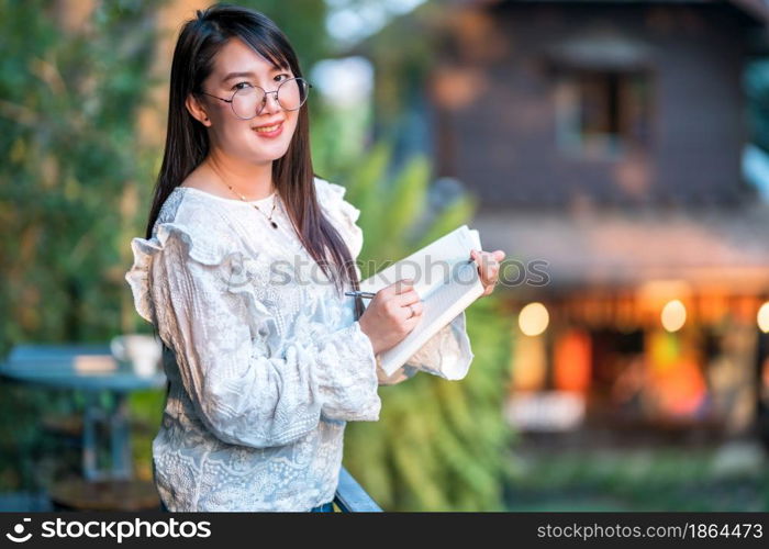 Happy of asian freelance people Businesswoman stand Taking written Notes to on notebook at the cafe,Business Lifestyle