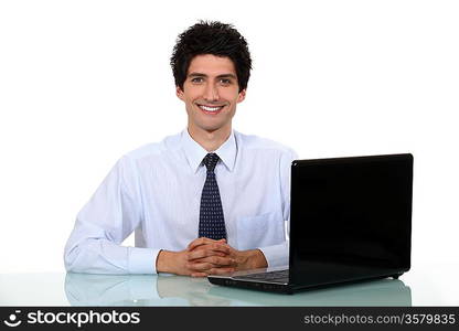 Happy office worker sat at his desk smiling