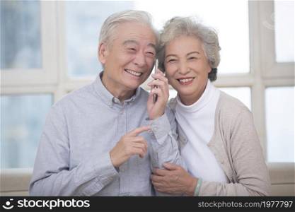 Happy old couple talking on the phone