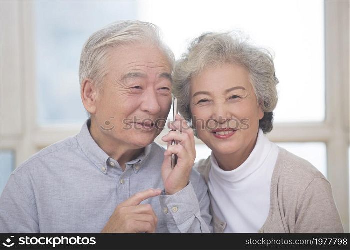 Happy old couple talking on the phone
