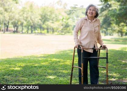 Happy old elderly Asian woman uses a walker for osteoarthritis rehabilitation physiotherapy in park.  Concept of happy retirement With care from a caregiver and Savings and senior health insurance